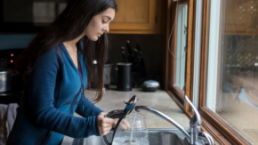 lady filling up kettle from tap
