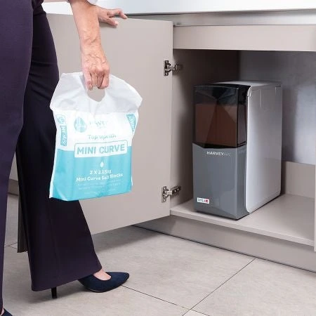 a woman refilling water softener salt